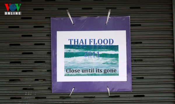 Tấm biển treo trước một cửa hàng bán đồng hồ tại Don Muang: "Lũ lụt Thái Lan năm 2011. Đóng cửa đến khi hết lụt".